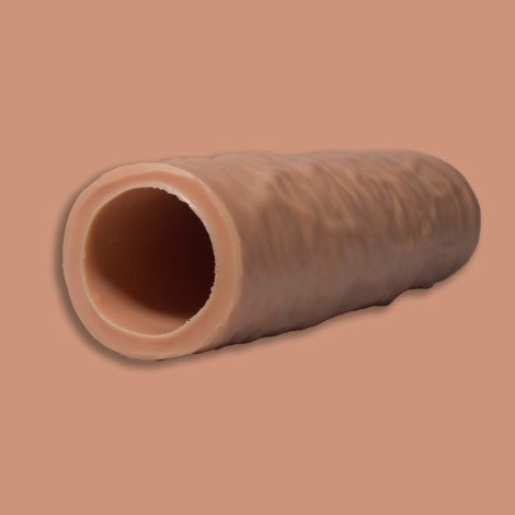 Looking up the open end of the A Godemiche Silicone Penis extender It is a cream colour on a similar cream colour back ground